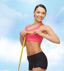 Image showing sporty woman measuring her breast