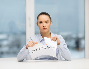 Image showing serious businesswoman tearing contract