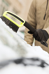 Image showing closeup of man cleaning snow from car