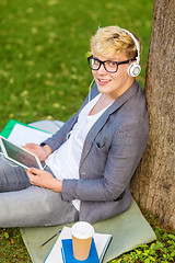 Image showing boy with headphones, tablet pc, books and coffee