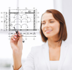 Image showing female architect drawing blueprint