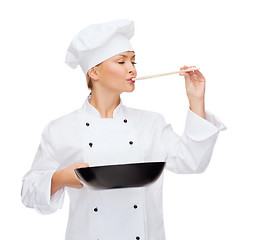 Image showing smiling female chef with pan and spoon