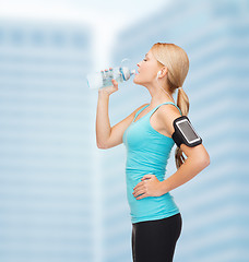 Image showing sporty woman running with smartphone and earphones