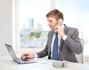 Image showing businessman with laptop computer and phone