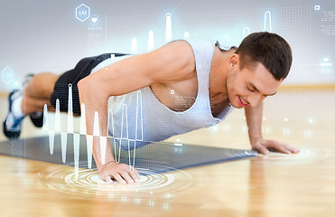 Image showing smiling man doing push-ups in the gym