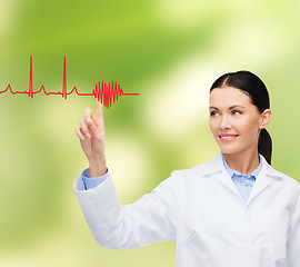 Image showing smiling female doctor pointing to cardiogram