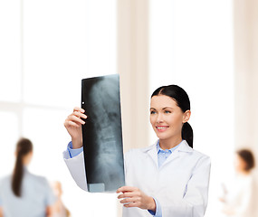 Image showing smiling female doctor looking at x-ray