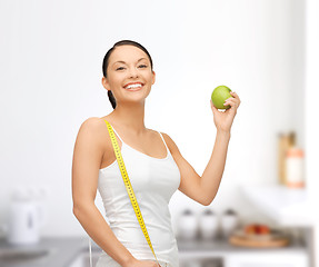 Image showing sporty woman with apple and measuring tape