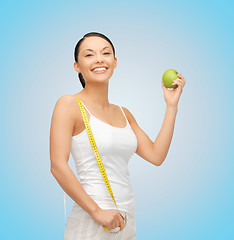 Image showing sporty woman with apple and measuring tape