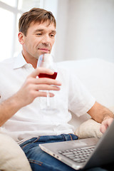 Image showing man with laptop computer and glass of red wine