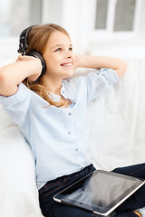 Image showing girl with tablet pc and headphones at home