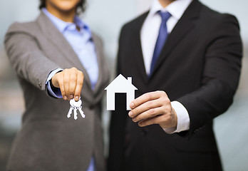 Image showing businessman and businesswoman holding white house