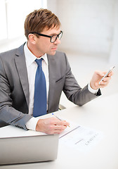 Image showing businessman working with laptop and smartphone