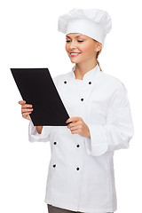 Image showing smiling female chef with black blank paper