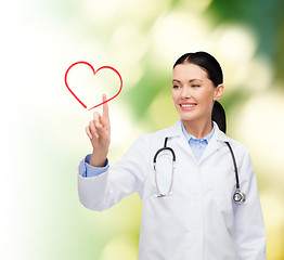 Image showing smiling female doctor pointing to heart