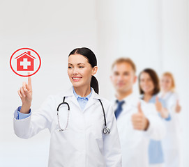 Image showing smiling female doctor pointing to something