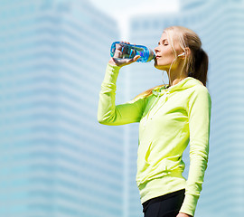 Image showing woman drinking water after doing sports outdoors