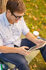 Image showing smiling male student in eyeglasses with tablet pc