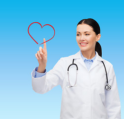 Image showing smiling female doctor pointing to heart