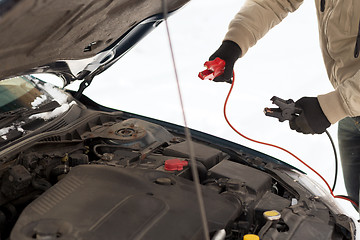 Image showing closeup of man under bonnet with starter cables