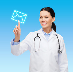 Image showing smiling female doctor pointing to envelope