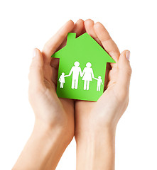 Image showing hands holding green house with family