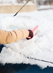 Image showing woman cleaning snow from car back window