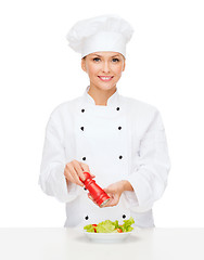 Image showing smiling female chef with preparing salad