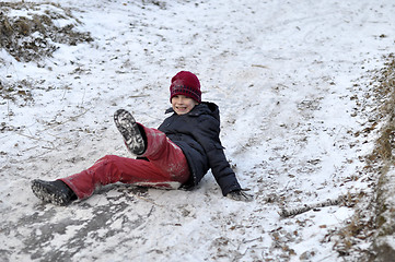 Image showing the teenage boy rides from a hill in the snow-covered wood.