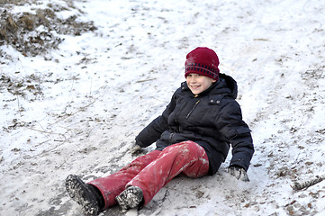 Image showing the teenage boy rides from a hill in the snow-covered wood.