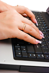 Image showing Women's hand writing on a laptop keyboard