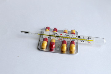 Image showing The increased temperature on a thermometer and pills.