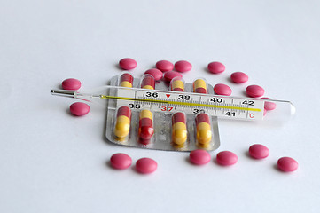 Image showing The increased temperature on a thermometer, pills and tablets.