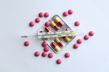 Image showing High temperature on a thermometer, pills and tablets.