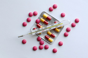 Image showing High temperature on a thermometer, pills and tablets.