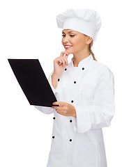 Image showing smiling female chef with black blank paper