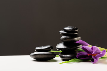 Image showing massage stones with flowers on mat