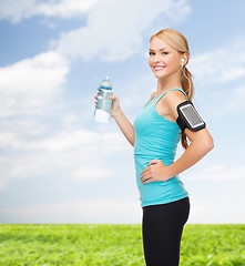 Image showing sporty woman running with smartphone and earphones