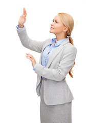 Image showing smiling businesswoman pointing to something