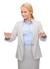 Image showing smiling businesswoman pointing to something