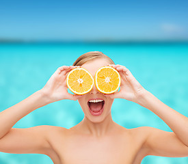 Image showing amazed young woman with orange slices