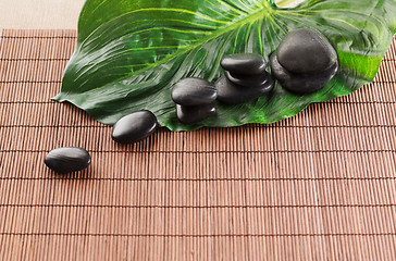 Image showing massage stones with flowers on mat