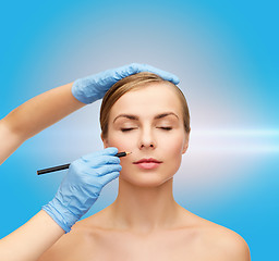 Image showing woman face and beautician hands with pencil