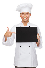 Image showing smiling female chef with black blank paper