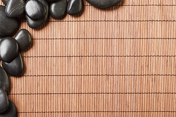 Image showing massage stones on bamboo mat