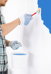 Image showing man with paintbrush and pot painting wall