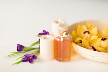 Image showing orchid flowers in bowl, oil, candles and irises