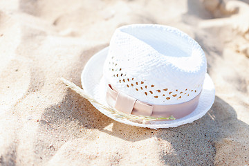 Image showing white straw hat lying in the sand on the beach