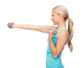 Image showing young sporty woman with light dumbbells