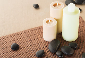 Image showing shampoo bottle, massage stones and candles